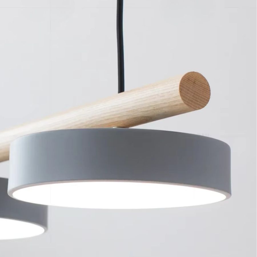 Gros plan sur un disque lumineux gris sous une barre en bois clair, au design scandinave épuré