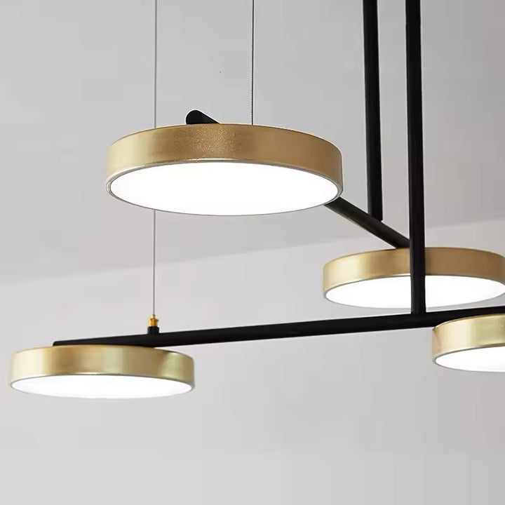 Détail des disques lumineux dorés reliés par des bras noirs, au design contemporain graphique et géométrique.