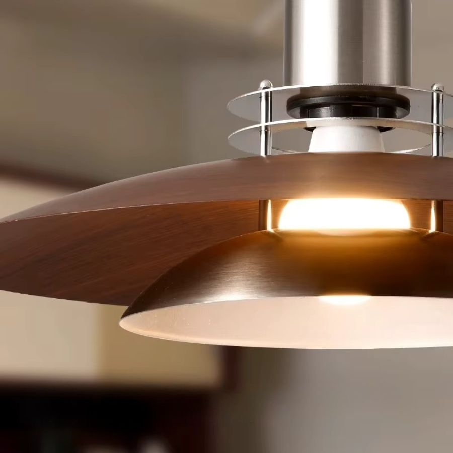 Gros plan sur le double réflecteur en métal effet noyer et satiné, diffusant une lumière chaude au style rétro.