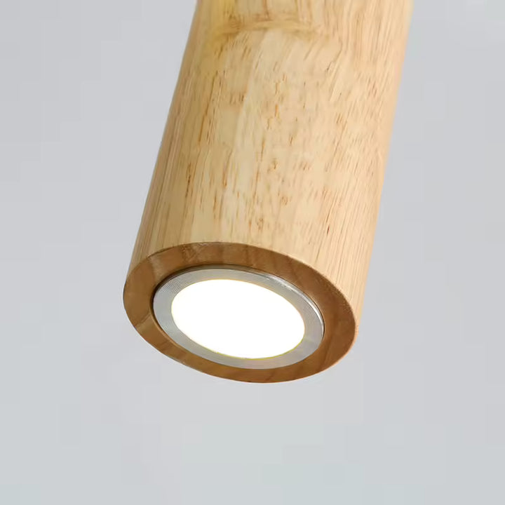 Détail de l’éclairage intégré d’une suspension cylindrique en bois clair au style naturel et minimaliste