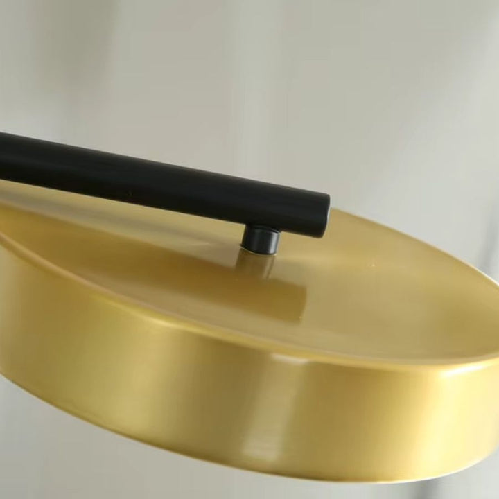 Détail de la finition dorée satinée reliée à un bras noir, révélant le style élégant et contemporain du lustre.