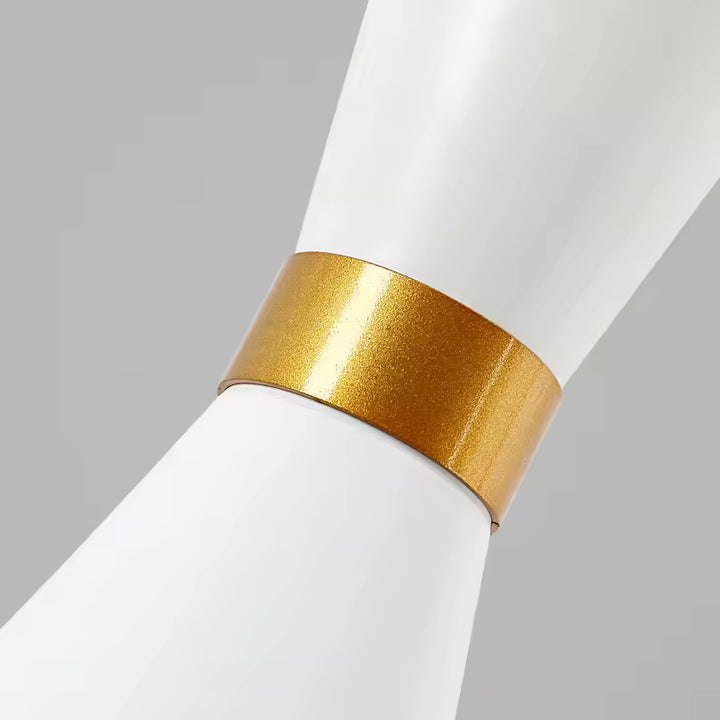 Gros plan sur la finition dorée d’une suspension sablier en métal blanc au style chic et contemporain