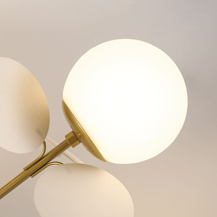 Vue rapprochée d'une ampoule globe en verre blanc et d'un pétale doré délicat