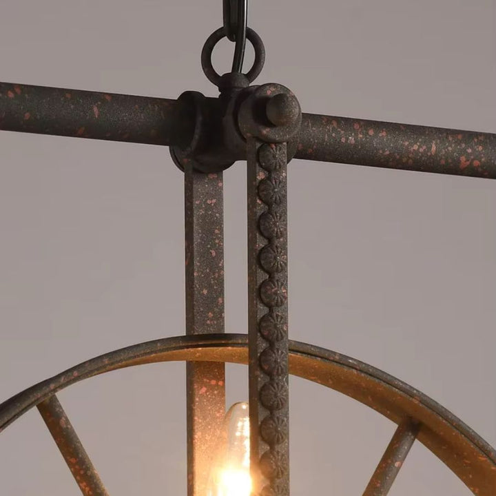 Détail de la structure en métal effet rouille et des ornements mécaniques d’un lustre roue au style industriel ancien