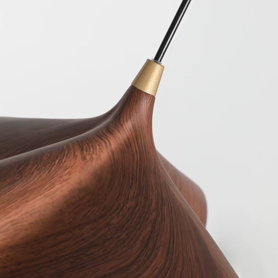 Détail de la suspension en résine effet bois noyer, avec courbes fluides et raccord doré au style organique