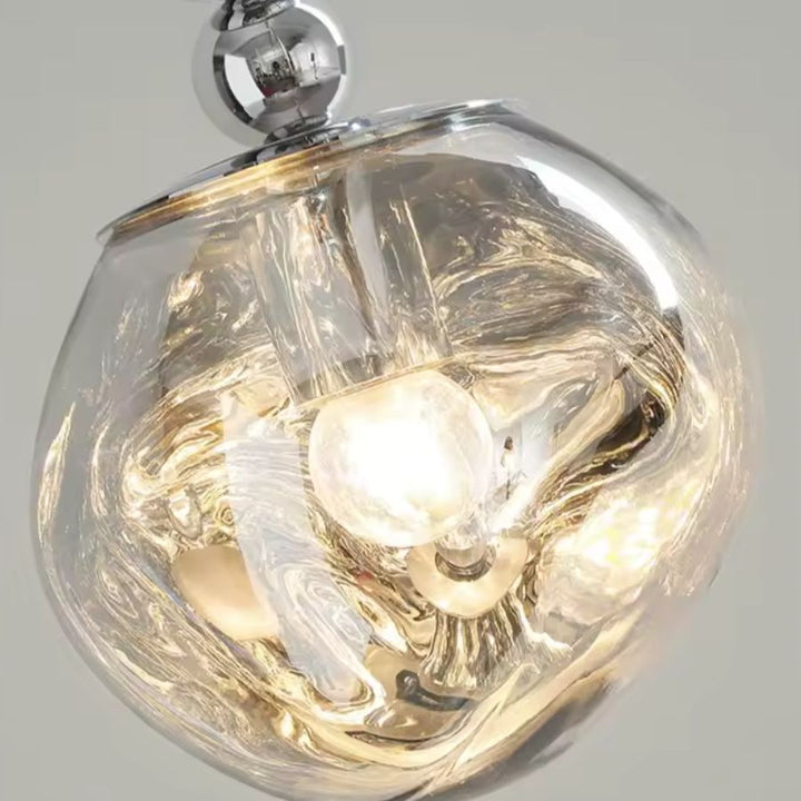 Gros plan sur le globe texturé transparent, dont les reliefs diffusent la lumière en reflets organiques et précieux