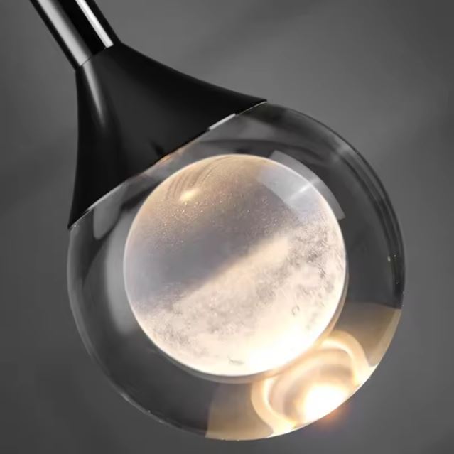 Détail d’un globe en verre transparent à cœur opalin, suspension moderne au style minimaliste haut de gamme.