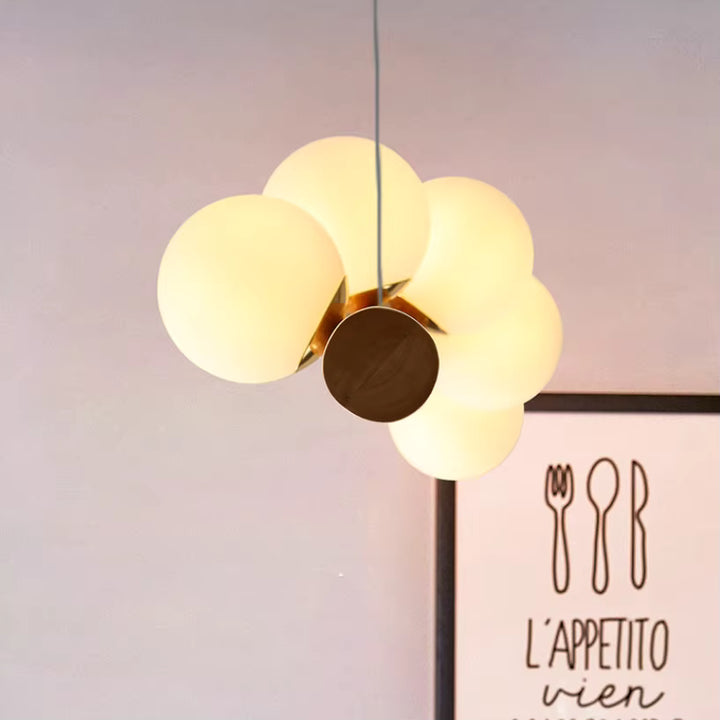 Gros plan sur les globes lumineux arrondis de la suspension en bois, au style organique, doux et contemporain.
