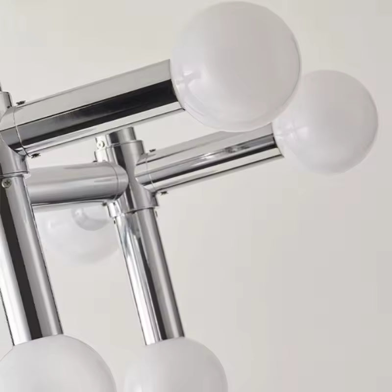 Gros plan sur les globes opalins et la structure chromée brillante d’une suspension au design moderne