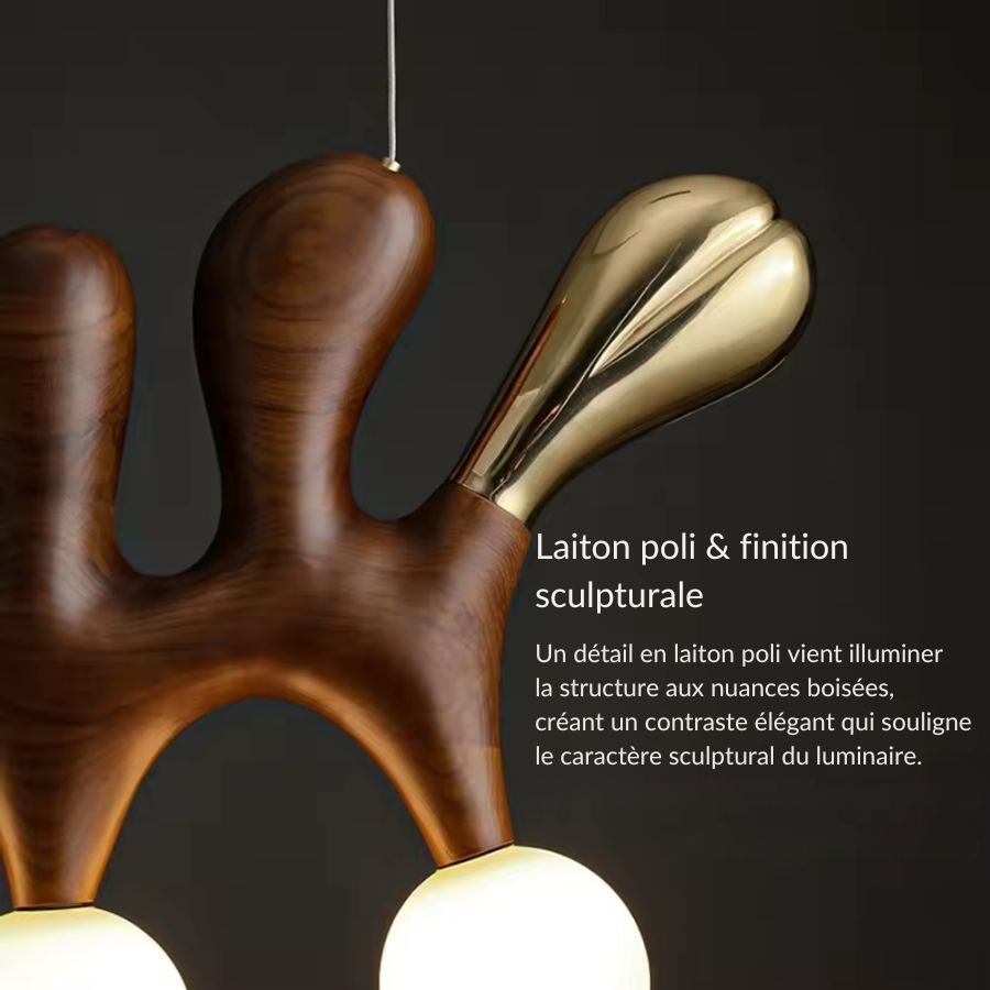 Gros plan sur le bois foncé et le détail en laiton poli qui souligne le design sculptural et le caractère haut de gamme du lustre