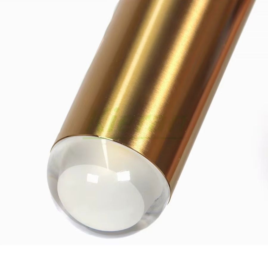 Gros plan sur le diffuseur en verre d’un luminaire doré allongé, avec finition satinée au design raffiné