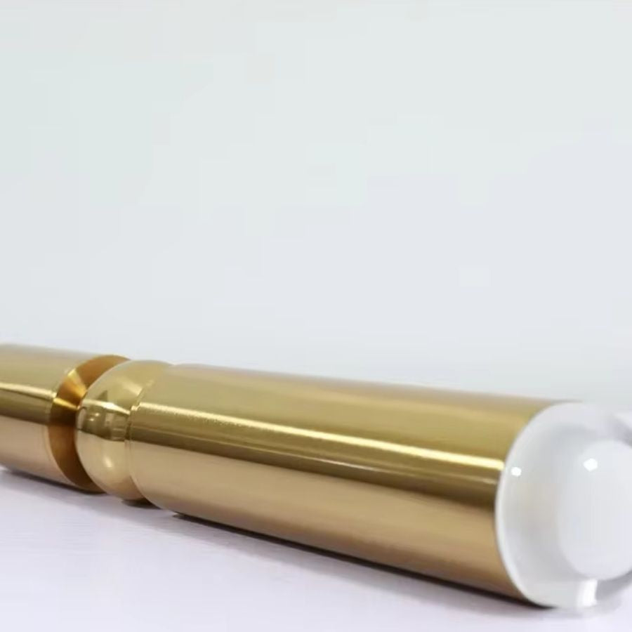 Gros plan sur la finition dorée et la sphère centrale d’un luminaire allongé au design contemporain raffiné