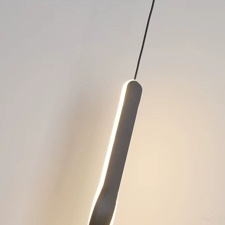 Vue rapprochée d’un luminaire noir très fin dont le contour LED souligne une ligne moderne et sculpturale
