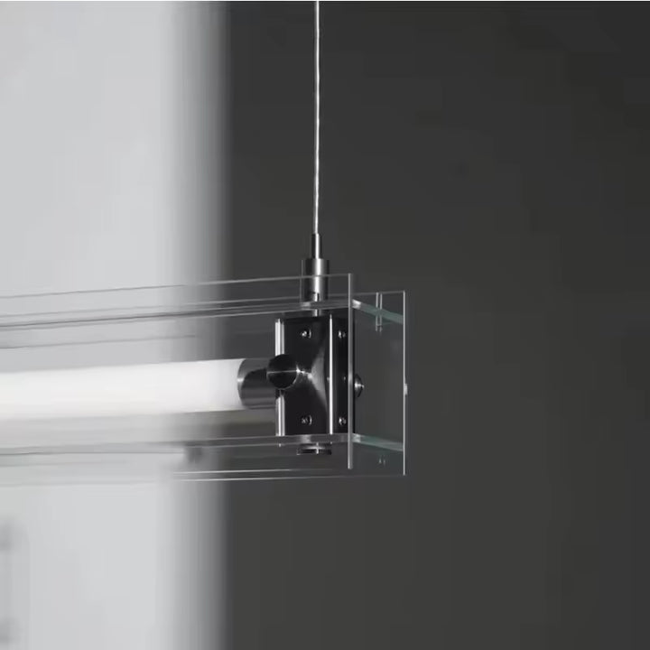 Détail de la fixation en acier inoxydable maintenant l’écrin de verre autour du tube lumineux au style minimaliste
