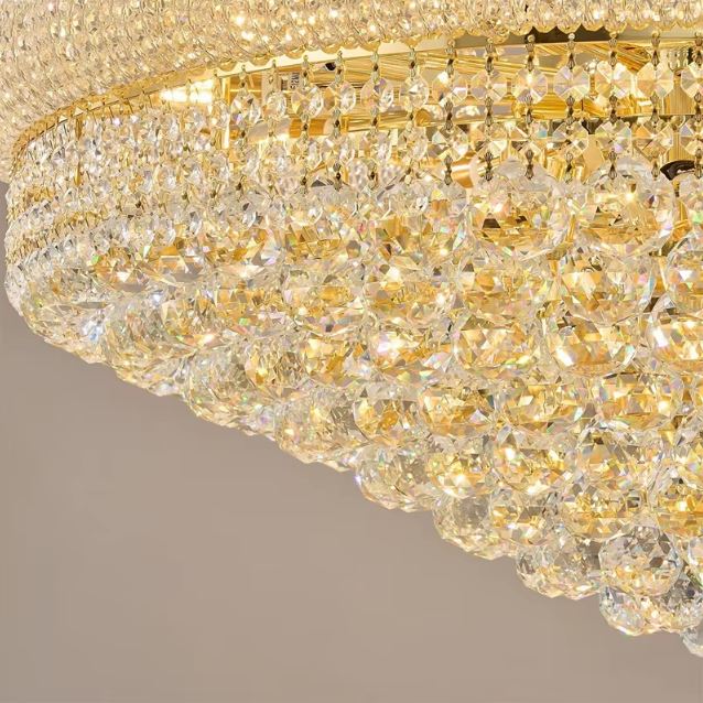 Détail de lustre en cristal doré à pampilles facettées, esprit chic et finition précieuse au style luxueux.