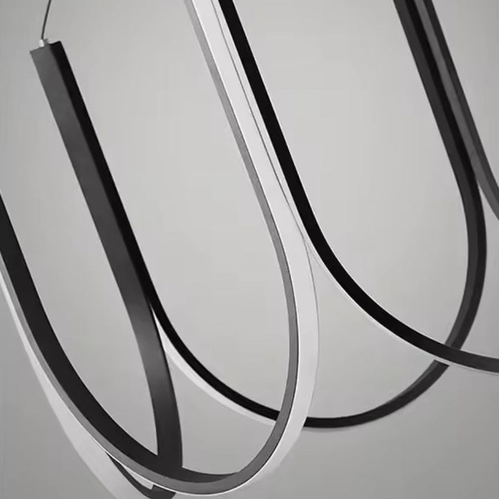 Détail des arceaux lumineux noirs d’une suspension LED au design minimaliste, graphique et contemporain