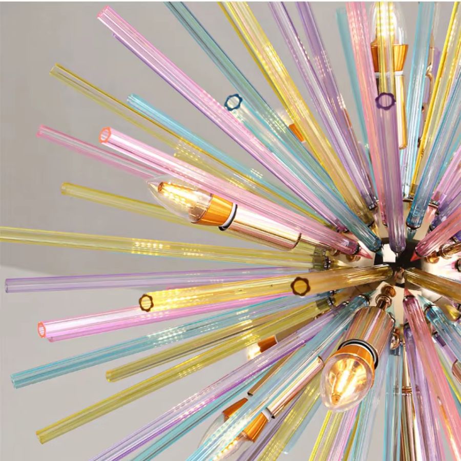 Gros plan sur les tiges de verre coloré et les douilles dorées d’un lustre au design éclatant et artistique