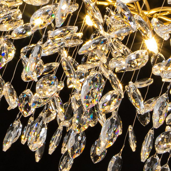 Détail des pampilles en cristal transparent suspendues sur une armature dorée, reflet de la lumière.