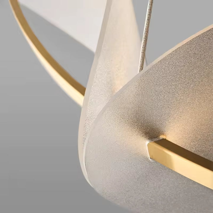 Gros plan sur les pétales blancs texturés et les finitions dorées d’un luminaire au design organique raffiné