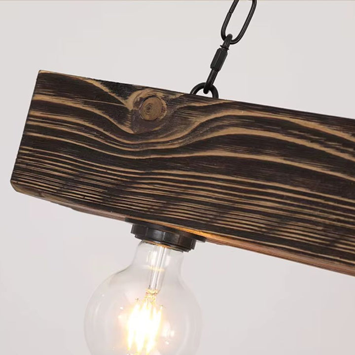 Gros plan sur la poutre en bois foncé veinée et l’ampoule apparente d’une suspension industrielle au style rustique