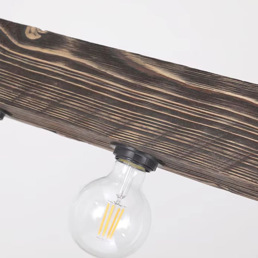 Détail de la poutre en bois veinée et de l’ampoule filament d’une suspension au style industriel rustique