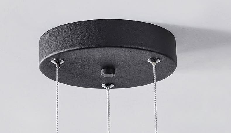 Gros plan sur le support de plafond rond et noir d'une suspension disque flottant.