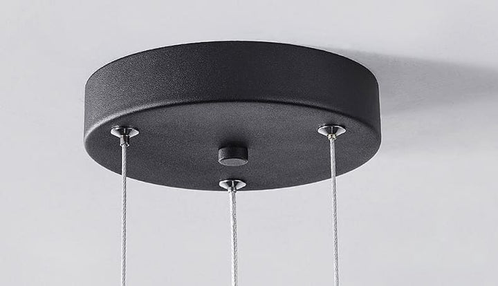 Gros plan sur le support de plafond rond et noir d'une suspension disque flottant.