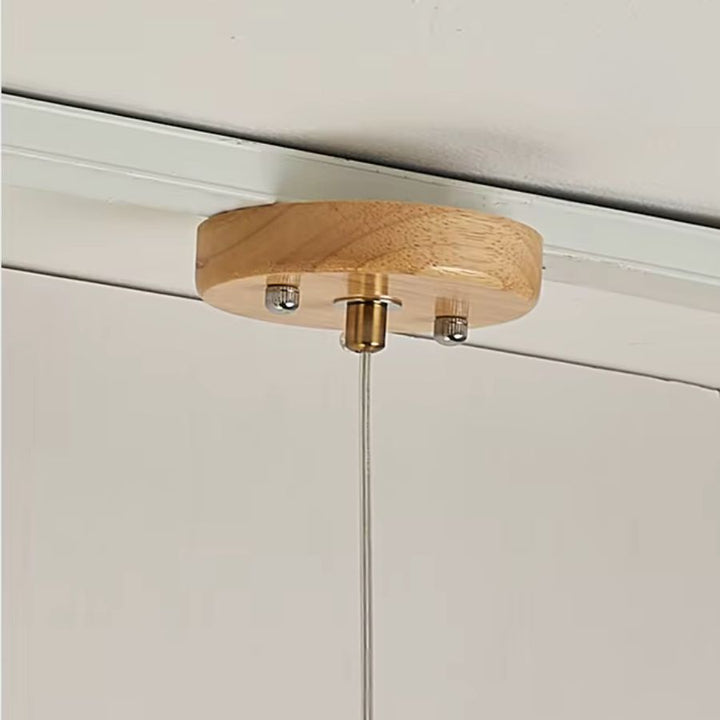 Détail de la rosace en bois de la suspension linéaire, avec fixation discrète au style naturel, épuré et contemporain.