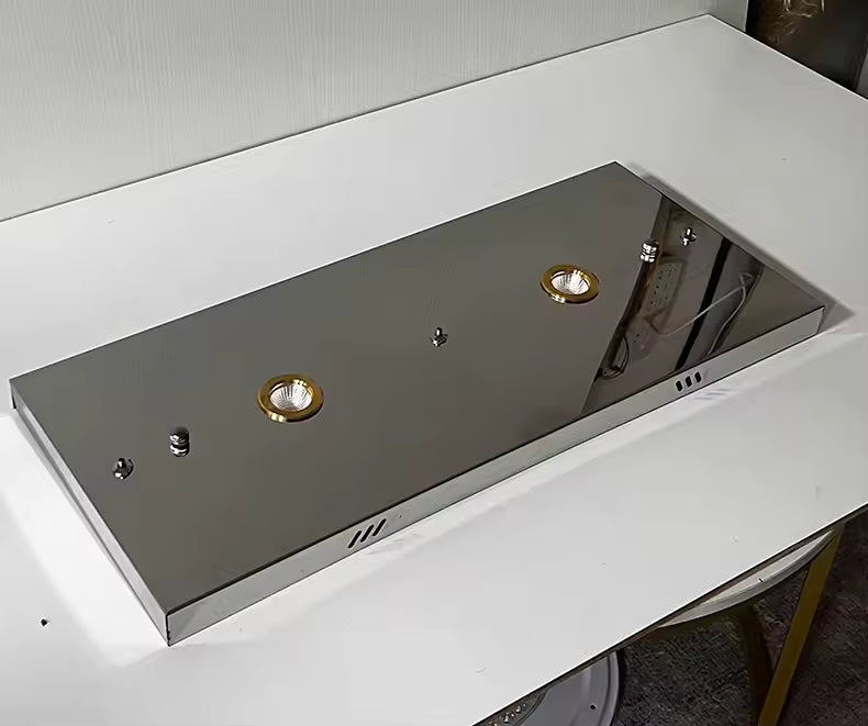 Vue rapprochée de la rosace rectangulaire chromée d'un lustre contemporain, avec deux spots encastrés et finition miroir.