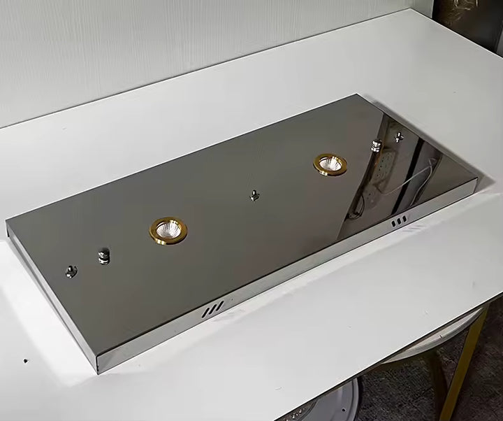 Vue rapprochée de la rosace rectangulaire chromée d'un lustre contemporain, avec deux spots encastrés et finition miroir.
