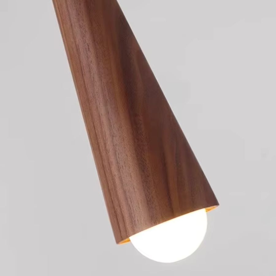 Gros plan sur la source LED sous le corps conique en noyer, révélant une finition chaleureuse et épurée