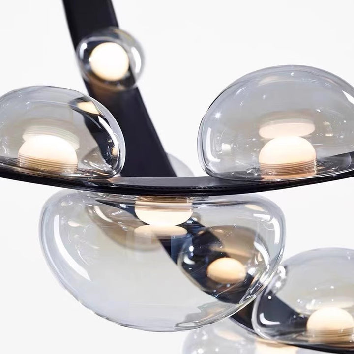 Gros plan sur les sphères lumineuses en verre transparent fixées sur une élégante lanière en cuir noir.