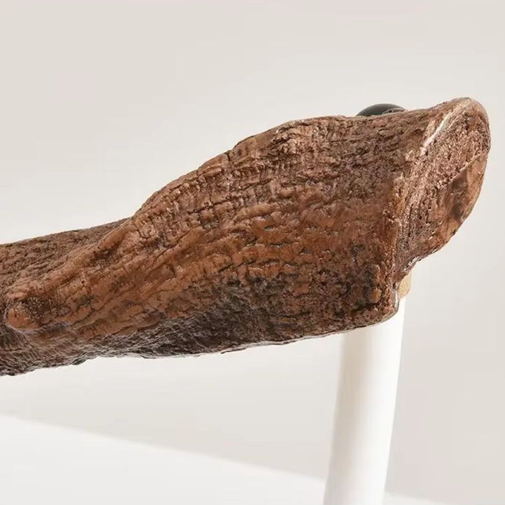 Gros plan sur l'extrémité d'une suspension en métal effet branche d'arbre, à la texture d'écorce sculptée et réaliste.