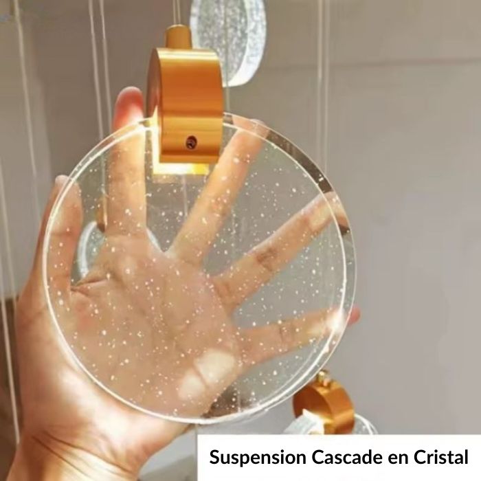 Détail d’une suspension cascade en cristal avec finition dorée et bulles élégantes.