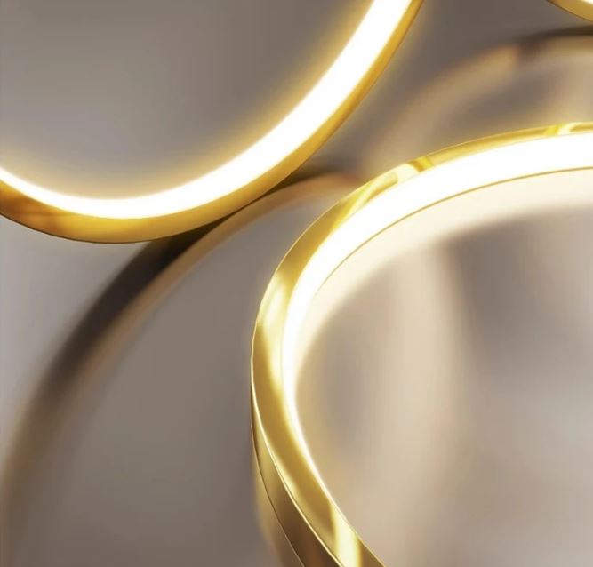 Zoom sur anneaux dorés LED d’une suspension cascade grande hauteur, avec finition brillante pour un intérieur chic et lumineux.