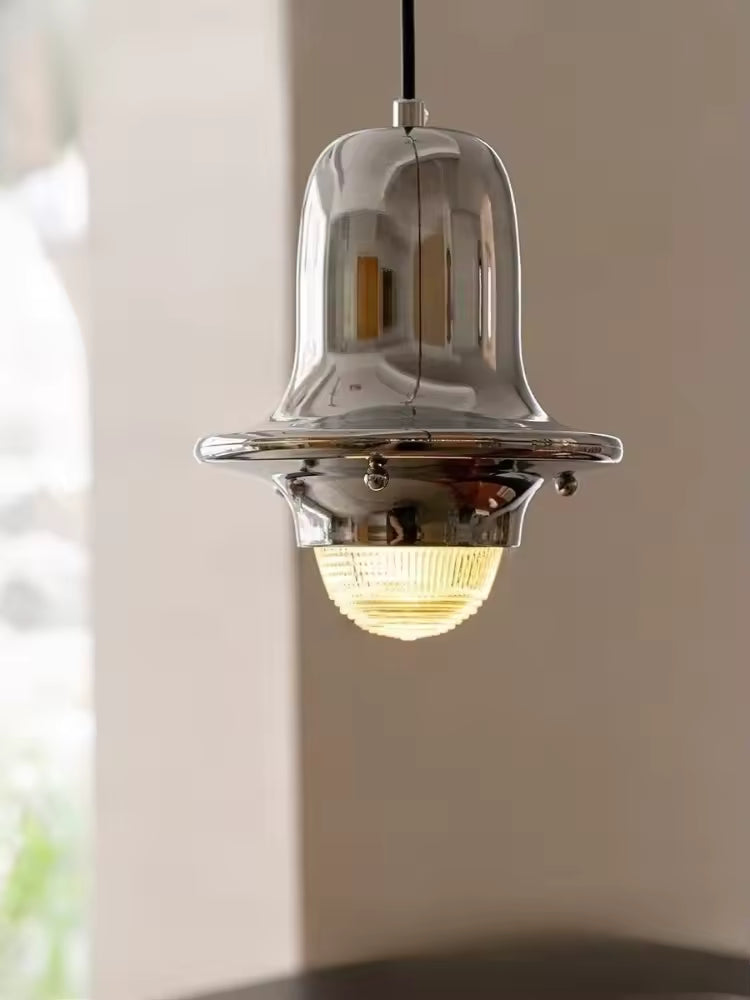 Gros plan sur la cloche en métal chromé et son diffuseur en verre strié, au style rétro sophistiqué