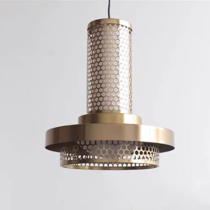 Vue rapprochée d’une suspension colonne en métal doré ajouré, structurée autour d’un large disque au style rétro design
