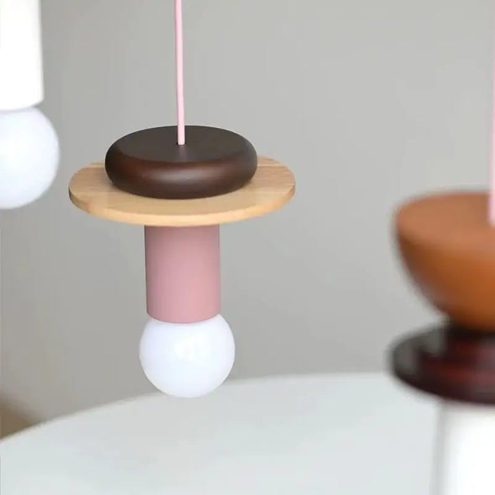 Détail de la suspension design en bois rose et marron installée dans un espace de vie lumineux.