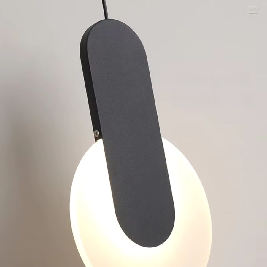 Gros plan sur une suspension disque lumineuse noire à bande verticale au design sculptural et contemporain
