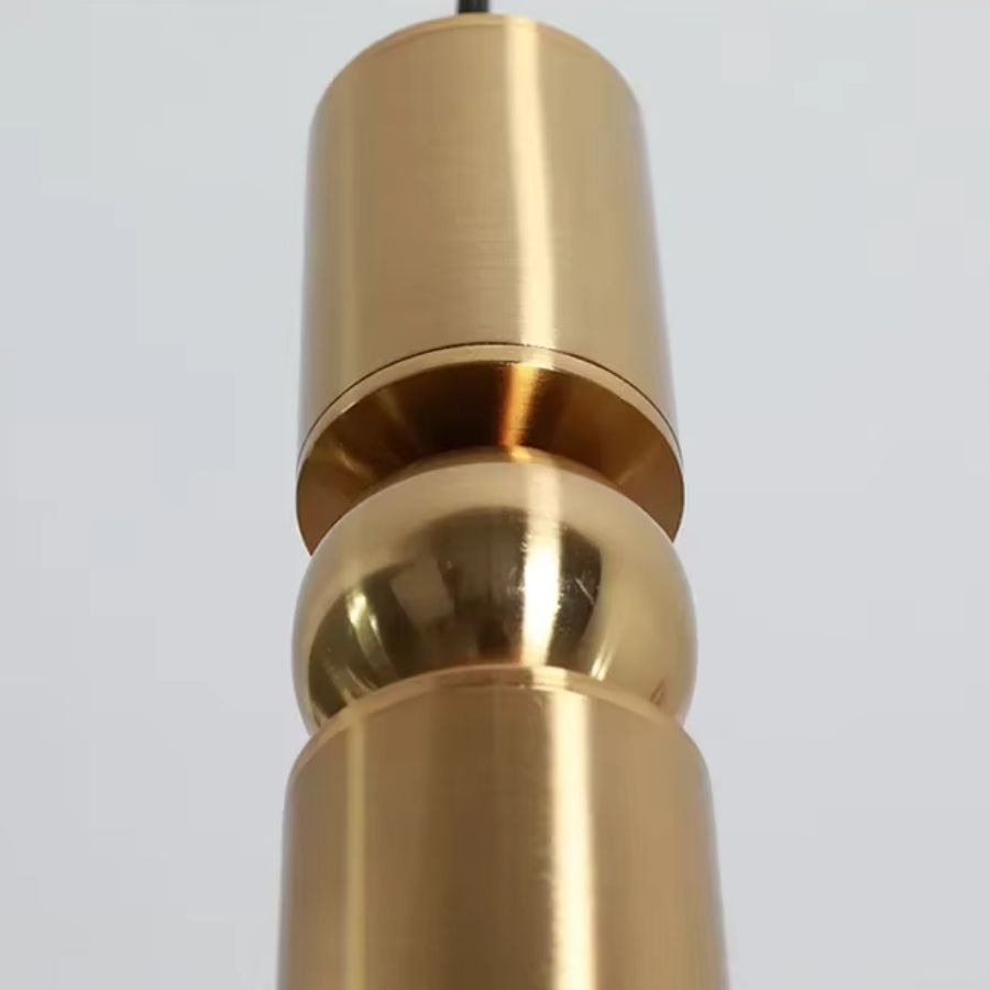 Détail de la sphère centrale et de la finition dorée satinée d’un luminaire tubulaire au design contemporain