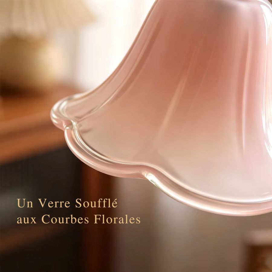 Gros plan sur le verre soufflé rose aux courbes florales d’une suspension vintage délicate et raffinée