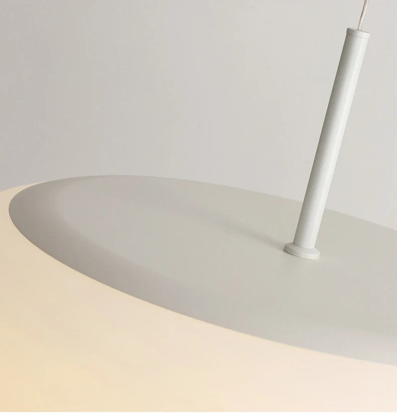 Gros plan sur le système de fixation d'une suspension galet en verre opalin.