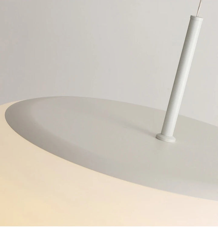 Gros plan sur le système de fixation d'une suspension galet en verre opalin.
