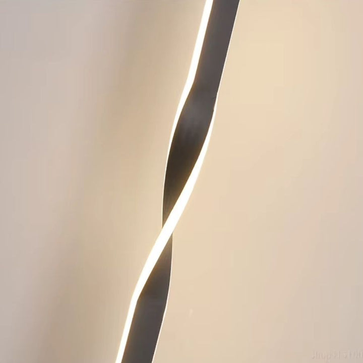 Gros plan sur la silhouette torsadée d’un luminaire au contour LED, entre design organique et minimalisme contemporain