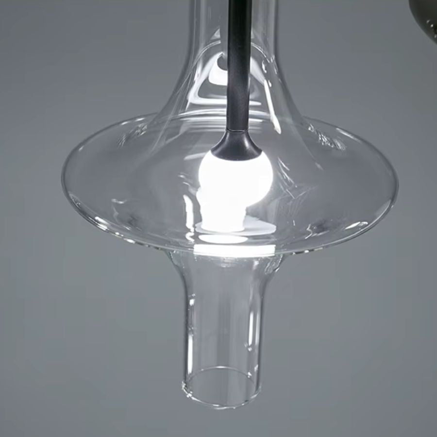 Gros plan sur une suspension totem en verre transparent, aux courbes sculpturales et au design contemporain épuré
