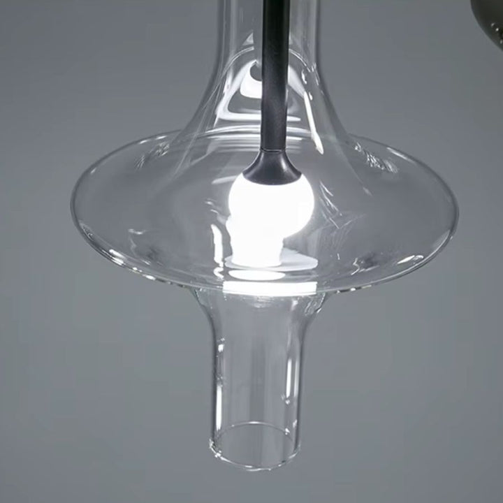 Gros plan sur une suspension totem en verre transparent, aux courbes sculpturales et au design contemporain épuré