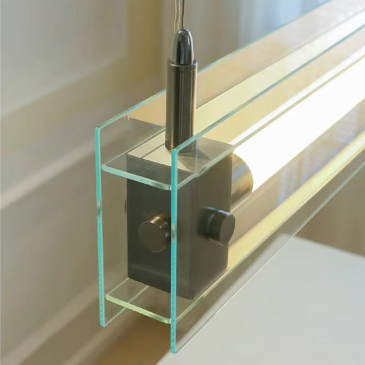 Vue rapprochée du câble et de la fixation en acier inoxydable intégrés à l’écrin de verre transparent du luminaire