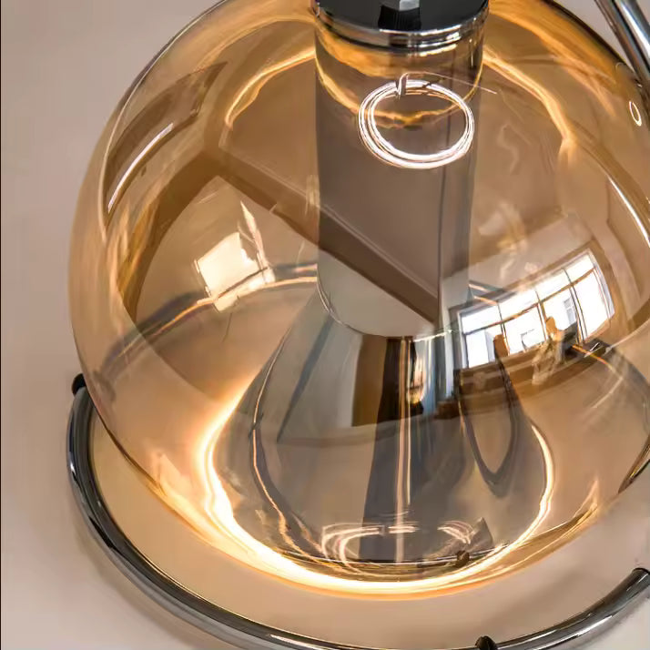 Détail du globe en verre ambré aux reflets chaleureux, associé à une structure chromée au style design