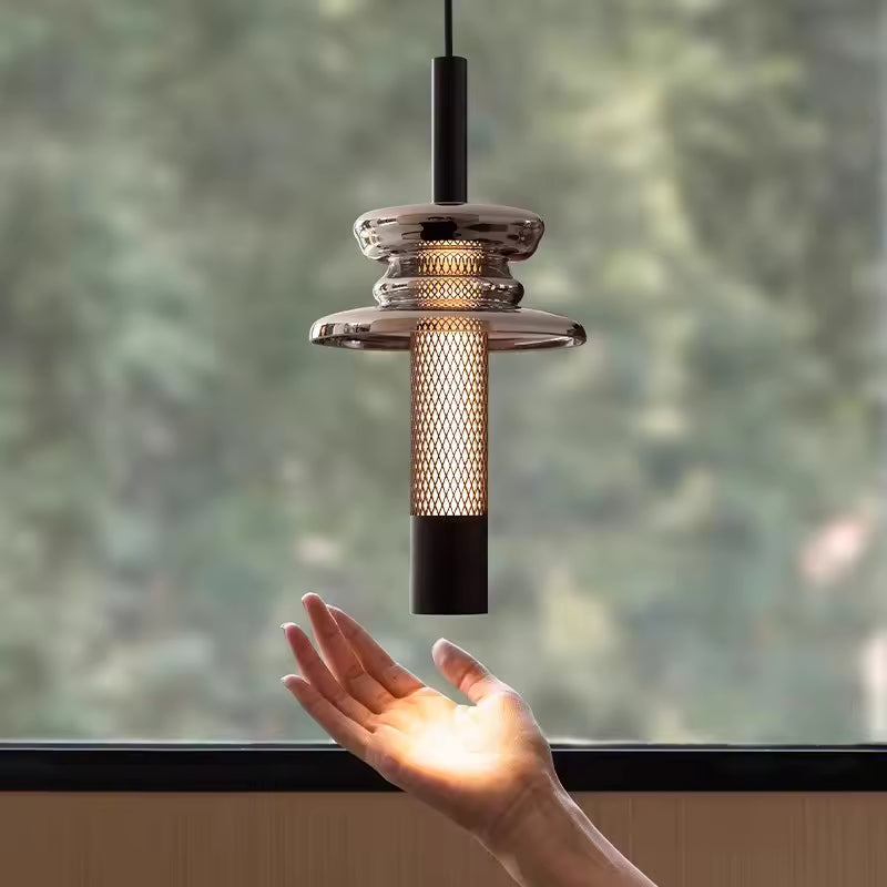 En gros plan, le verre fumé et la trame métallique ajourée révèlent un design contemporain aux accents industriels