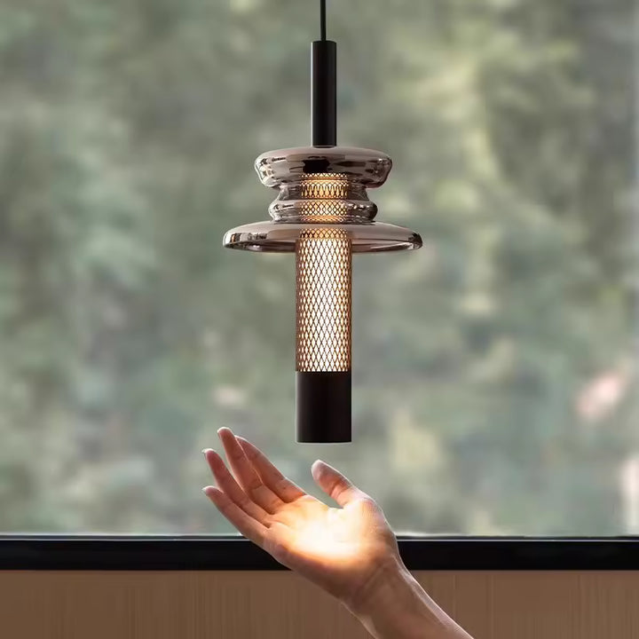 En gros plan, le verre fumé et la trame métallique ajourée révèlent un design contemporain aux accents industriels